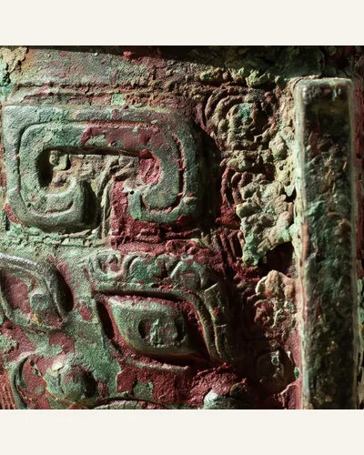 An archaic Chinese bronze ritual vessel with heavy malachite-green encrustation and taotie decoration. — the encrustation.