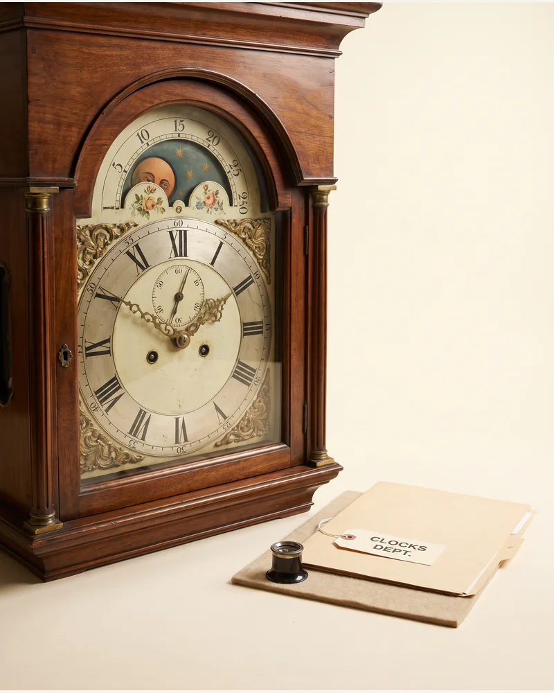 An eighteenth-century longcase clock hood with a painted arched dial.