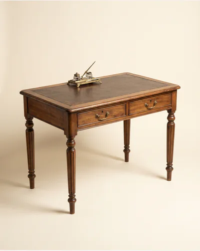 A Regency mahogany library table on turned and reeded legs with brass castors.
