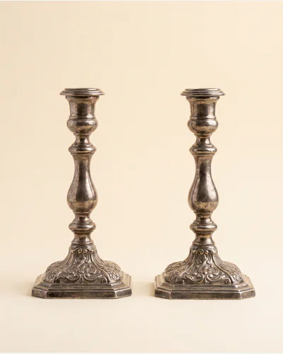 A pair of cast silver candlesticks with shell-and-scroll knopped stems.